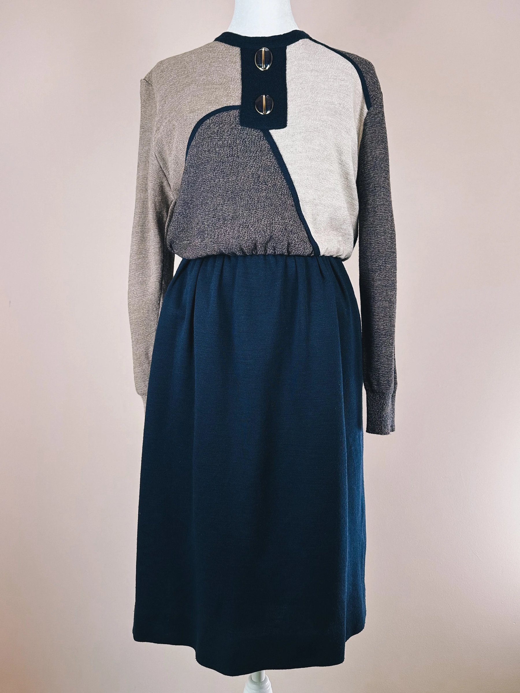 A long-sleeve color-block dress featuring a button detail at the neckline and a cinched waist.