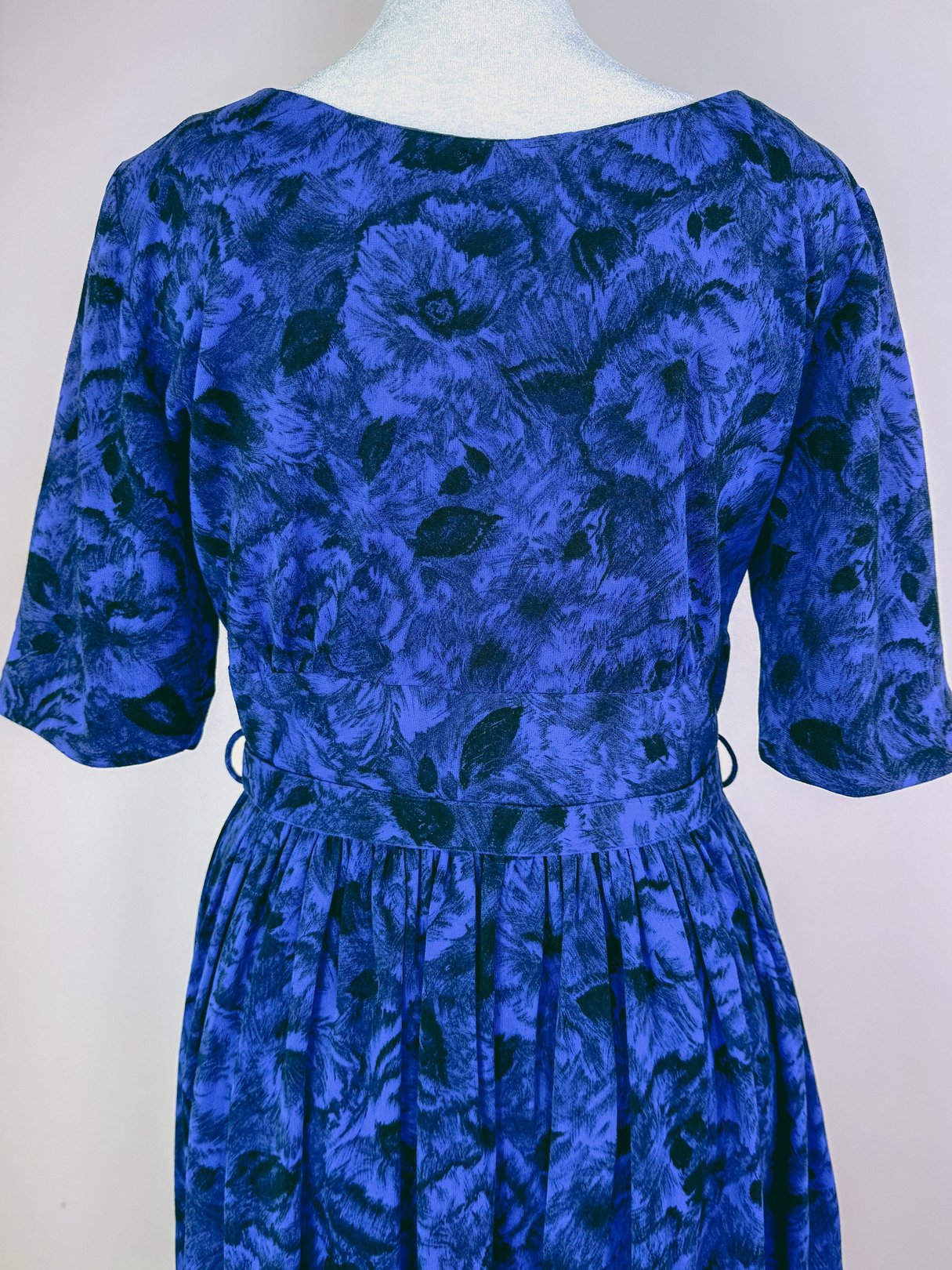Midnight blue 1960s women's jazz dress featuring a floral pattern and fitted waist.