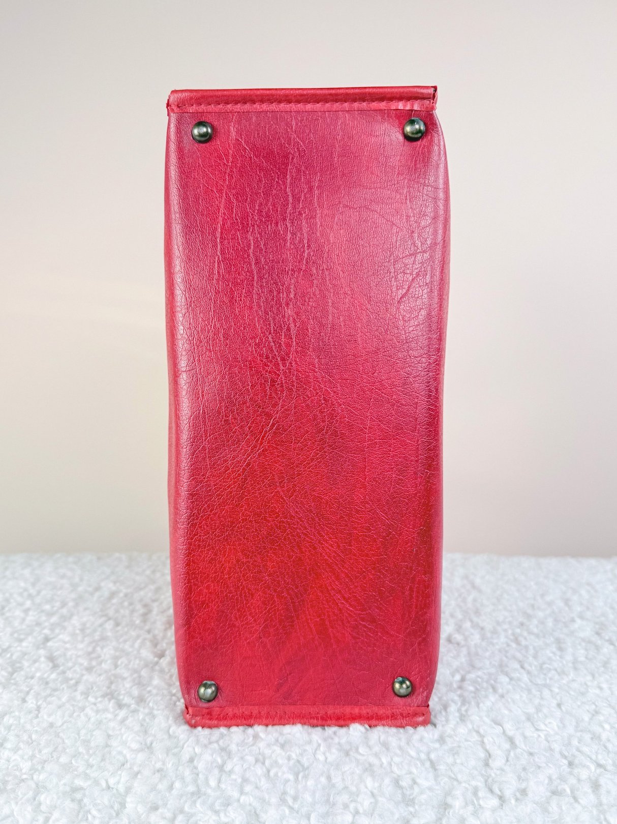 Redline Retro Satchel Tote in red leather with a smooth finish and metal studs on the base, reflecting a 1970s design.