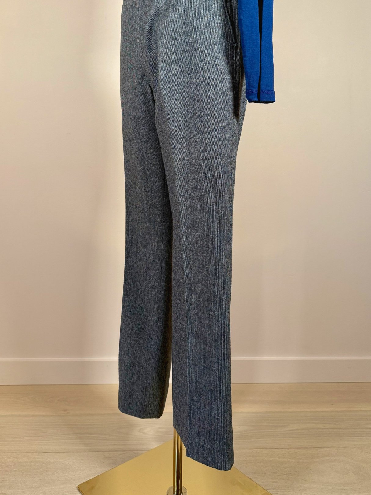 Blue men's trousers from the 1980s displayed on a stand.