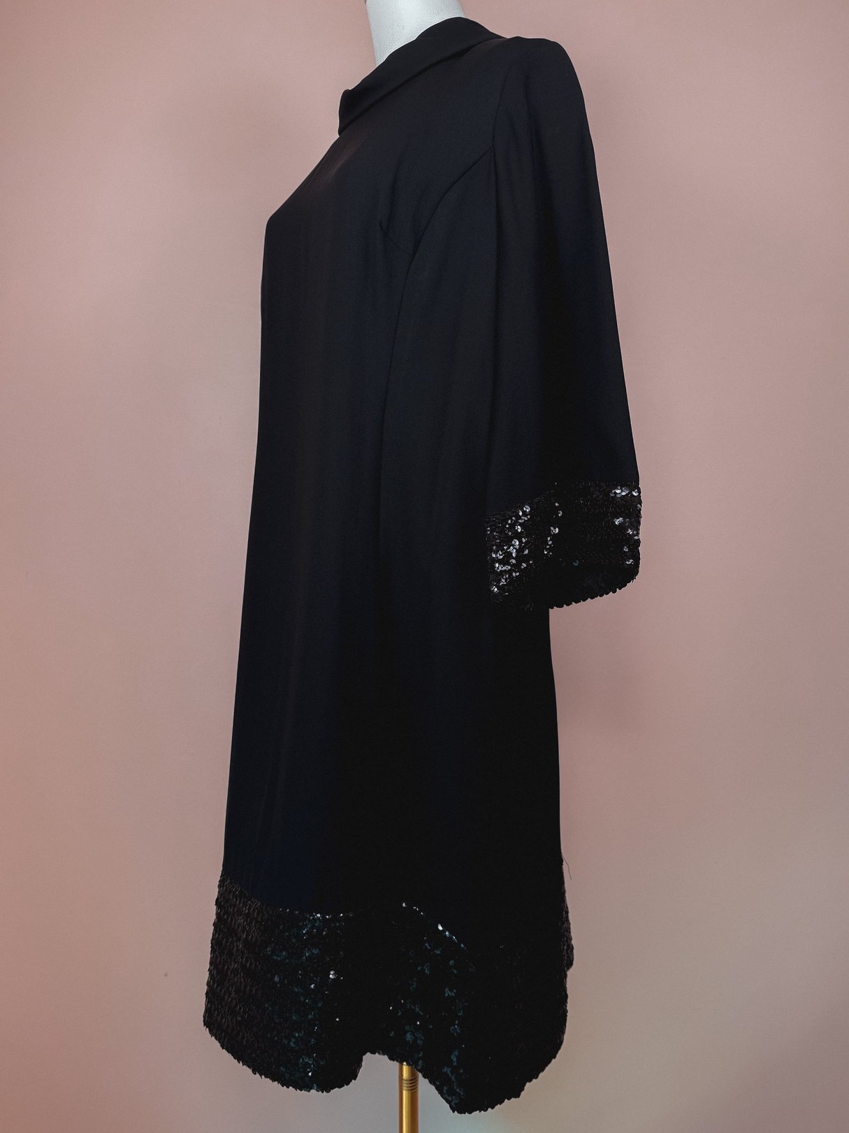 Black 1960s Mod Sparkle Dress featuring a loose silhouette and sequin detailing at the hem.