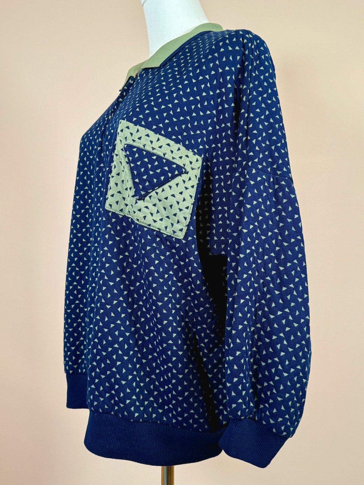 Navy blue women's triangle top from the 1980s featuring a patterned design and a green accent patch.