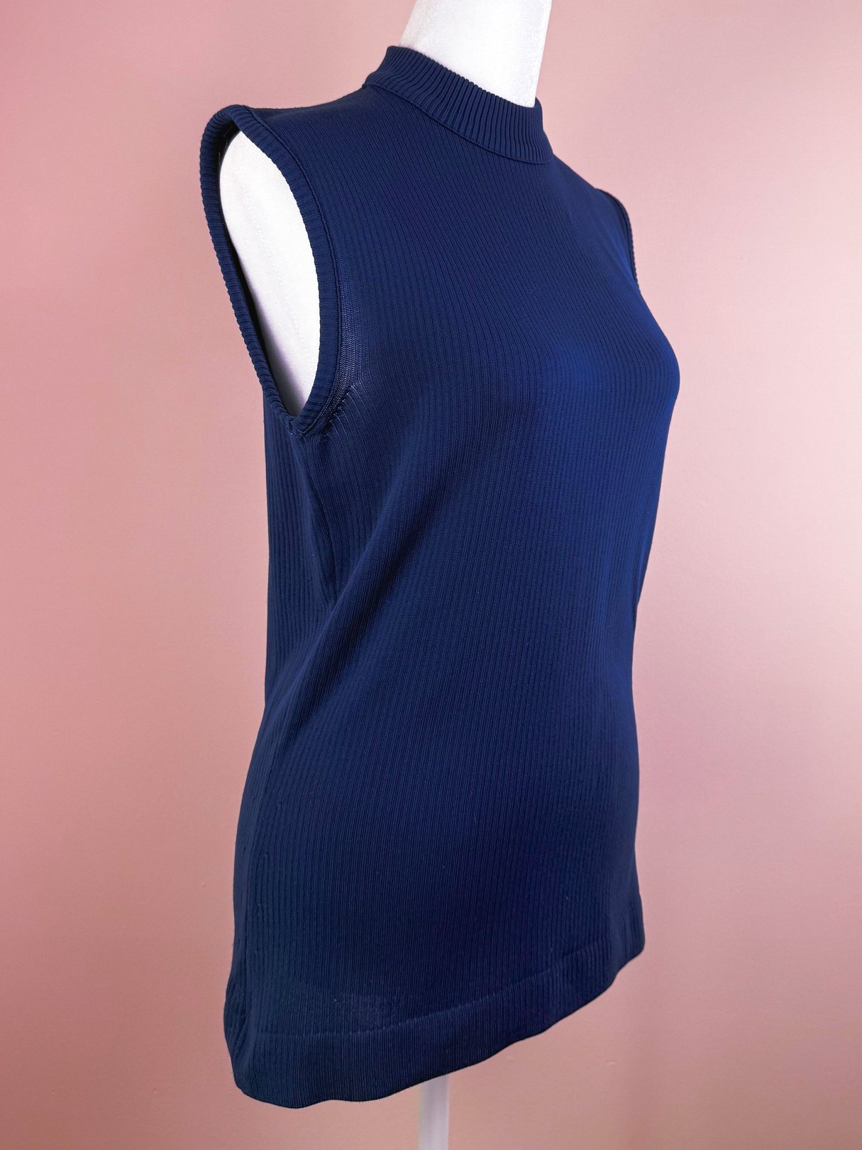 Navy blue ribbed mock neck top with sleeveless design, styled for women and inspired by 1970s fashion.