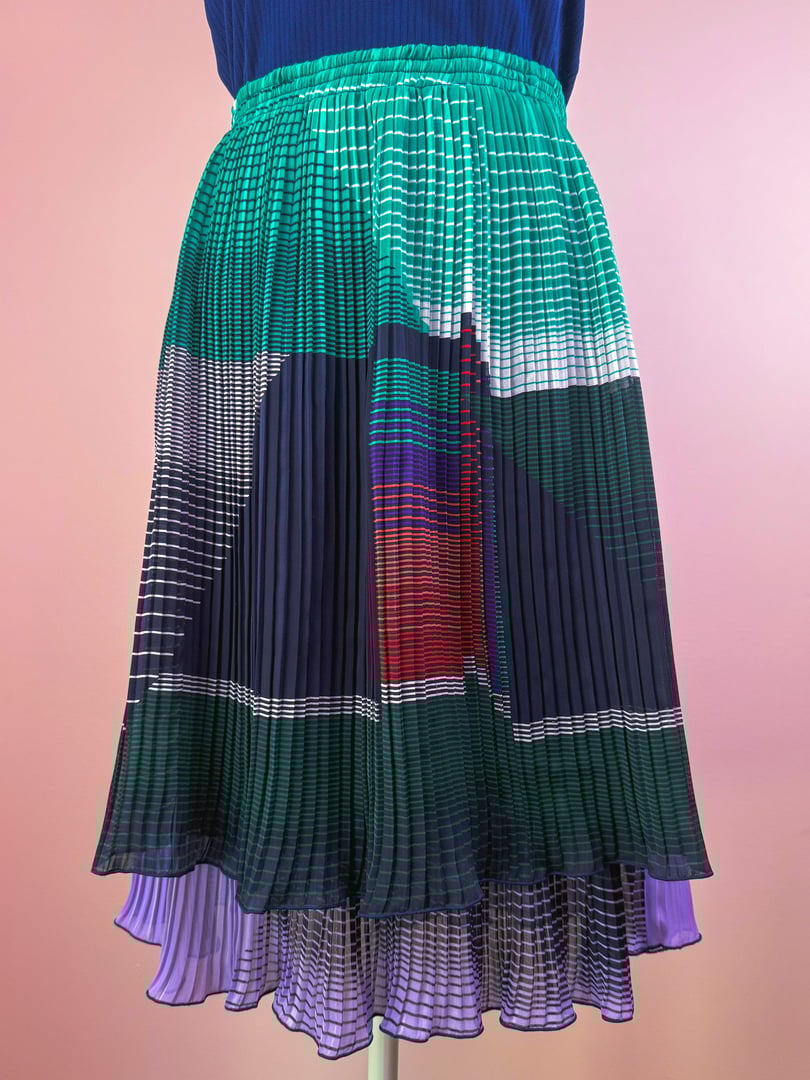 Pleated skirt in green, showcasing a 1970s design with bold patterns and varying textures.