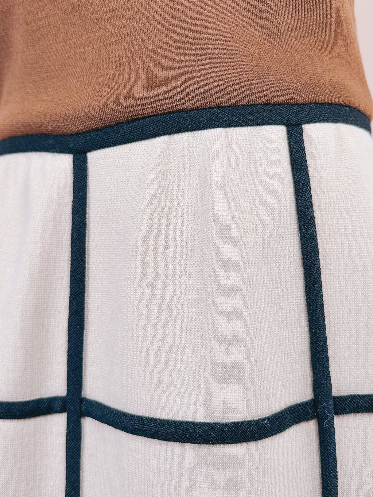 Brown and white 1960s-inspired British Mod Squared Dress featuring a fitted bodice and square-patterned skirt with contrasting trim.