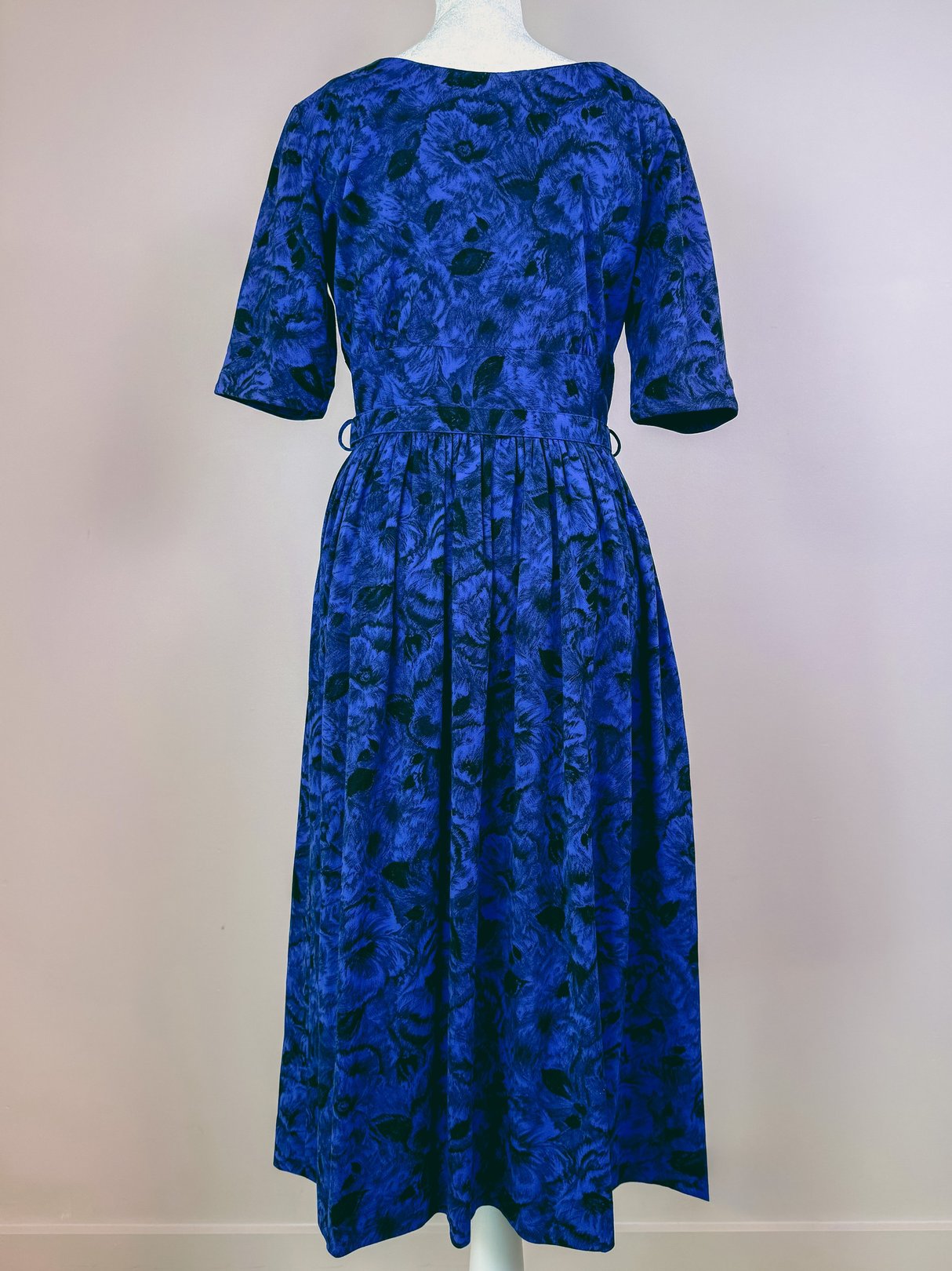 Midnight blue 1960s women's dress featuring a floral pattern and modest knee-length skirt.