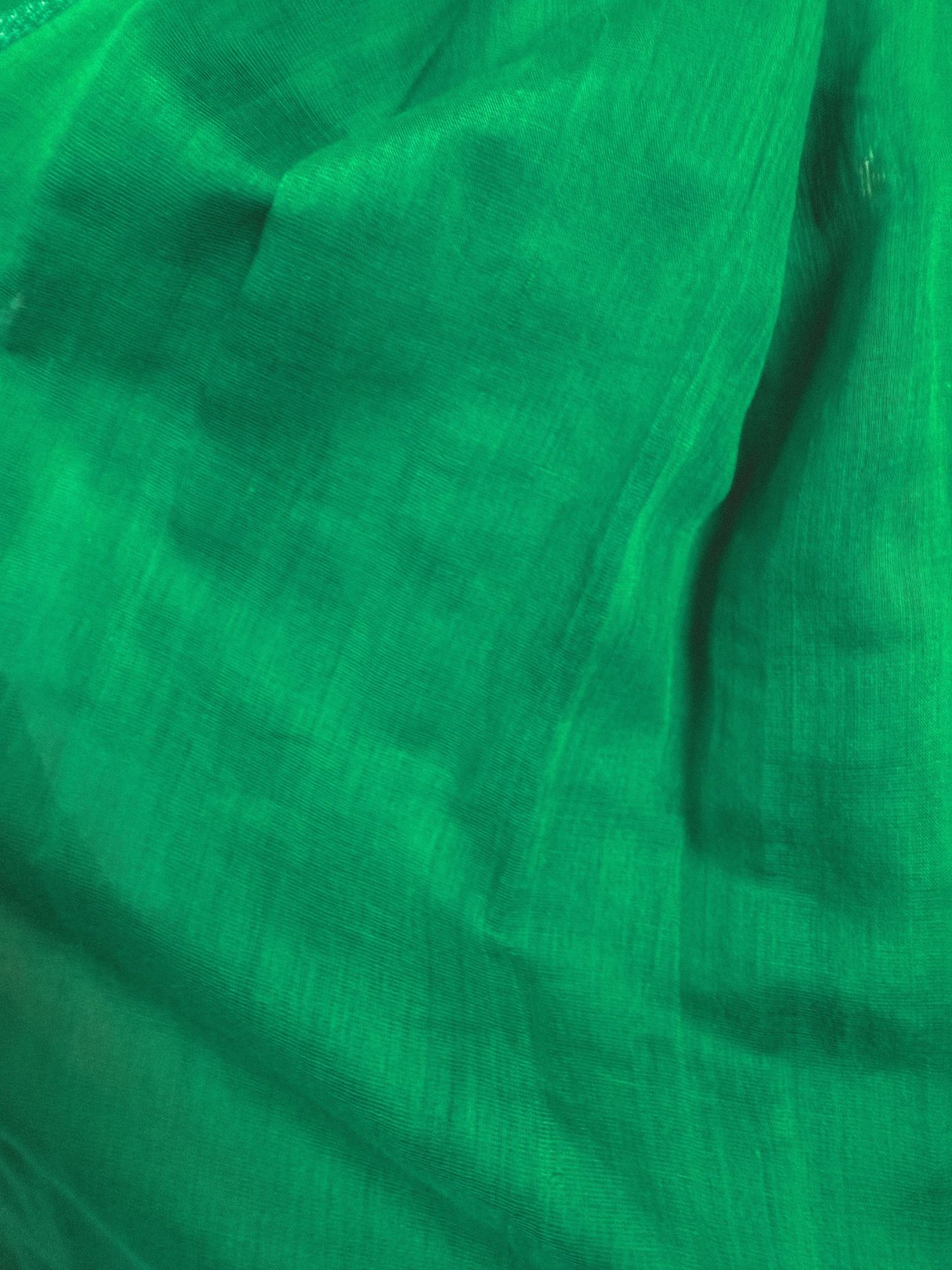 Emerald green fabric of a 1950s-style dress showcasing a starburst design.
