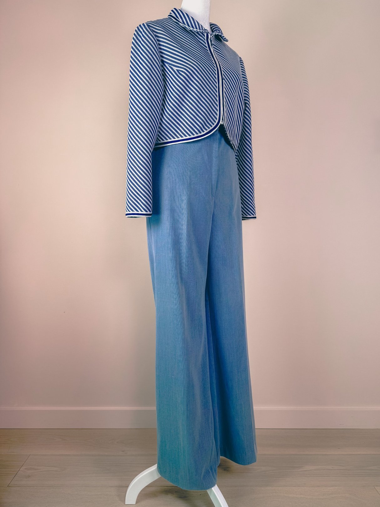 Light blue 1970s women's pants on a mannequin, styled with a striped jacket.