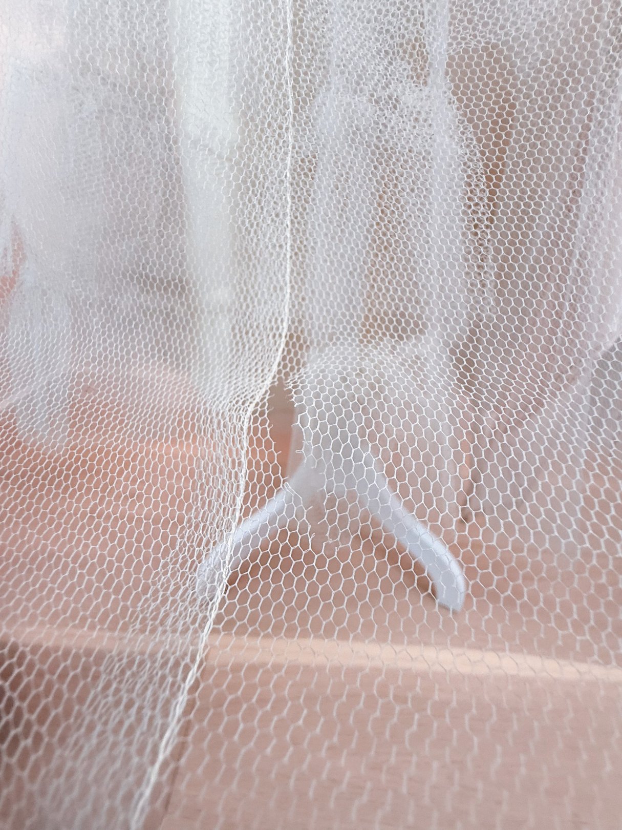 A sheer silver dress with a textured mesh overlay, suitable for women and inspired by 1950s fashion.