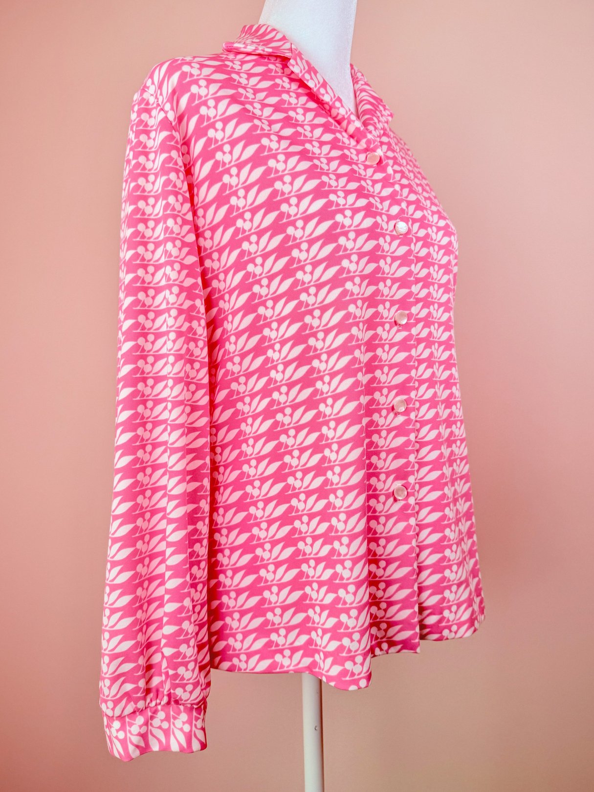 Pink 1970s-style women's blouse featuring a cherry petal print and long sleeves.