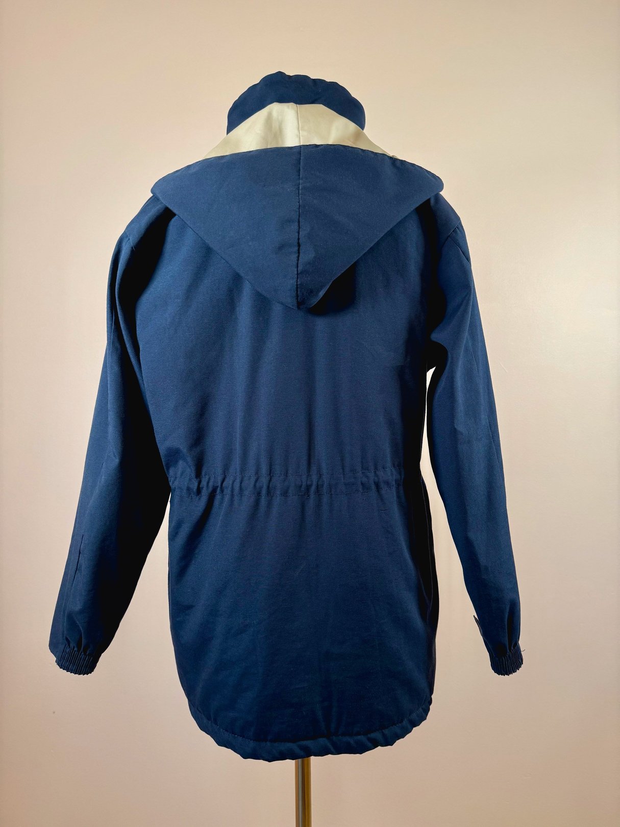 Navy blue utility field coat for women featuring a hood and elasticized waist, typical of the 1970s style.