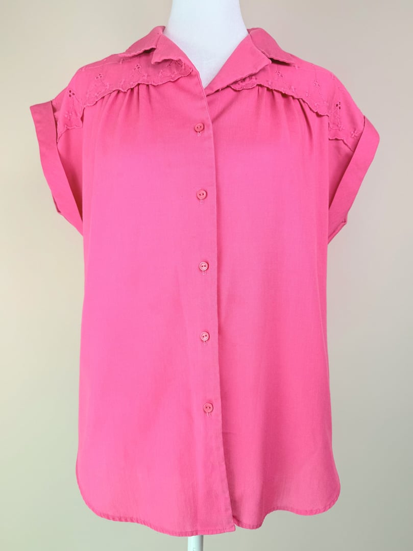 Pink short-sleeve button-up top for women featuring lace detailing, from the 1980s.
