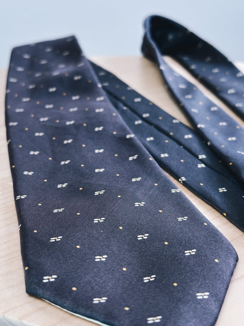 A brown tie featuring a yellow dot pattern, reflecting a 1970s style for women’s accessories.