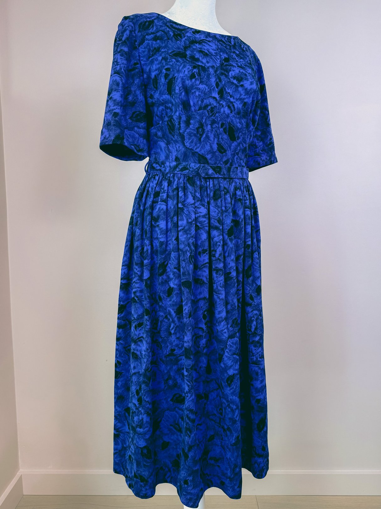 Midnight blue 1960s women's dress featuring short sleeves and a flowing skirt with a floral pattern.