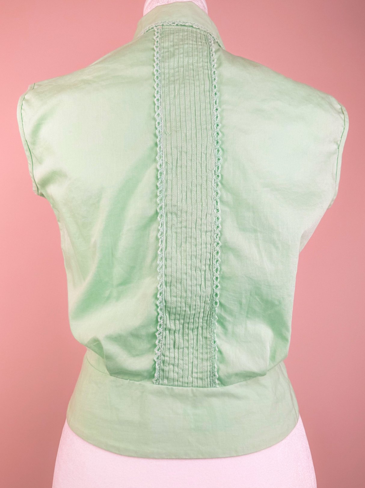 Mint chip ice cream top for women from the 1950s, featuring a white color and pleated detail at the back.