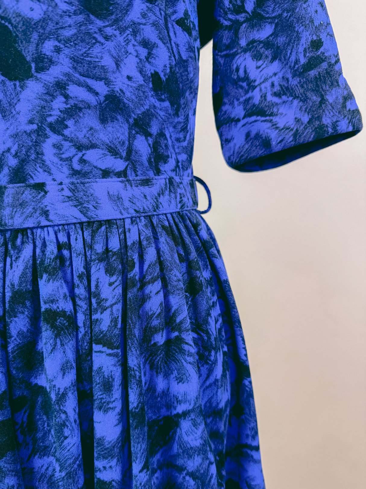 Midnight blue 1960s women's jazz dress featuring a textured print and a flared skirt.