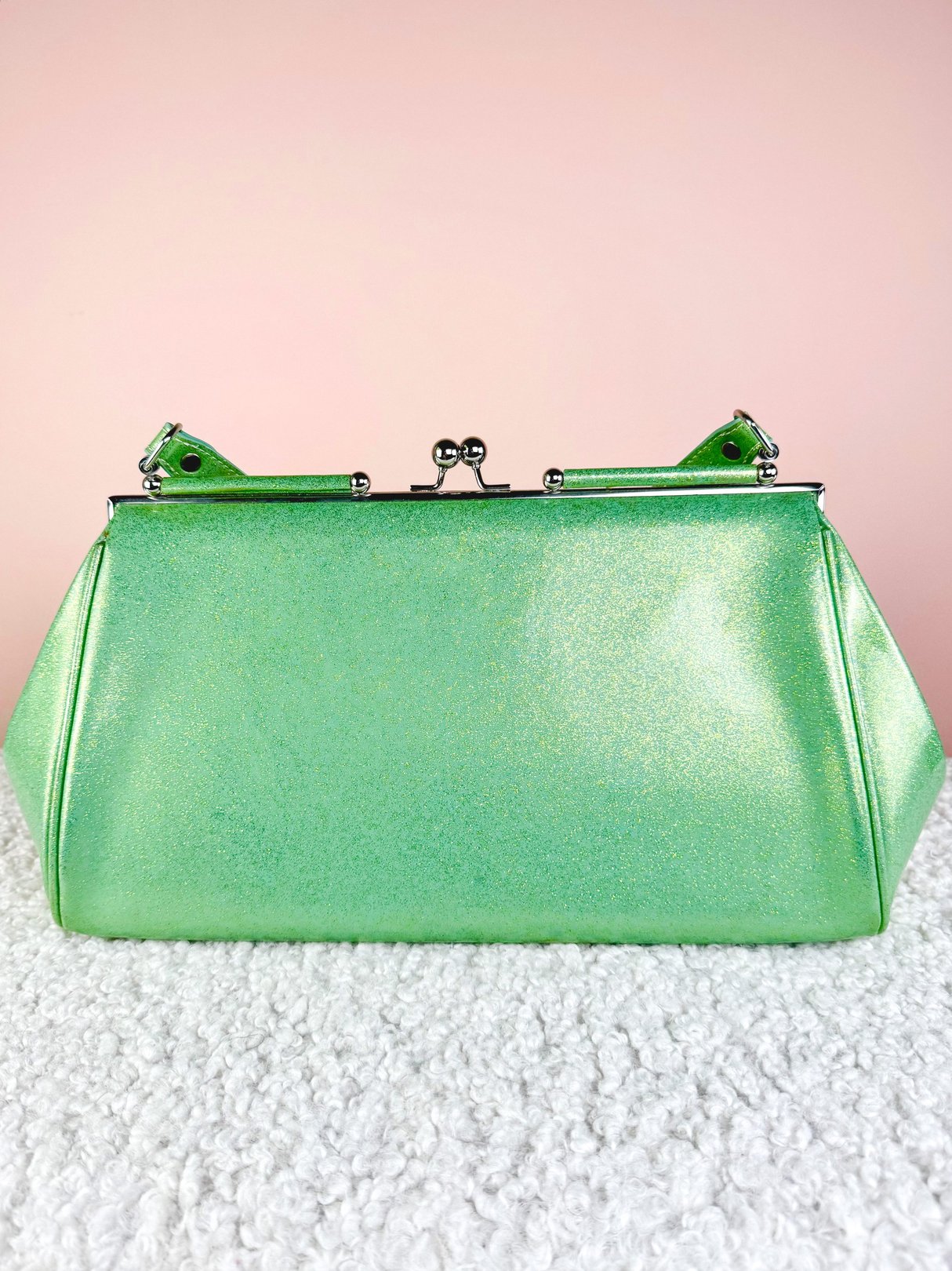 Sparkling mint green 1950s handbag with a clasp closure and structured shape.
