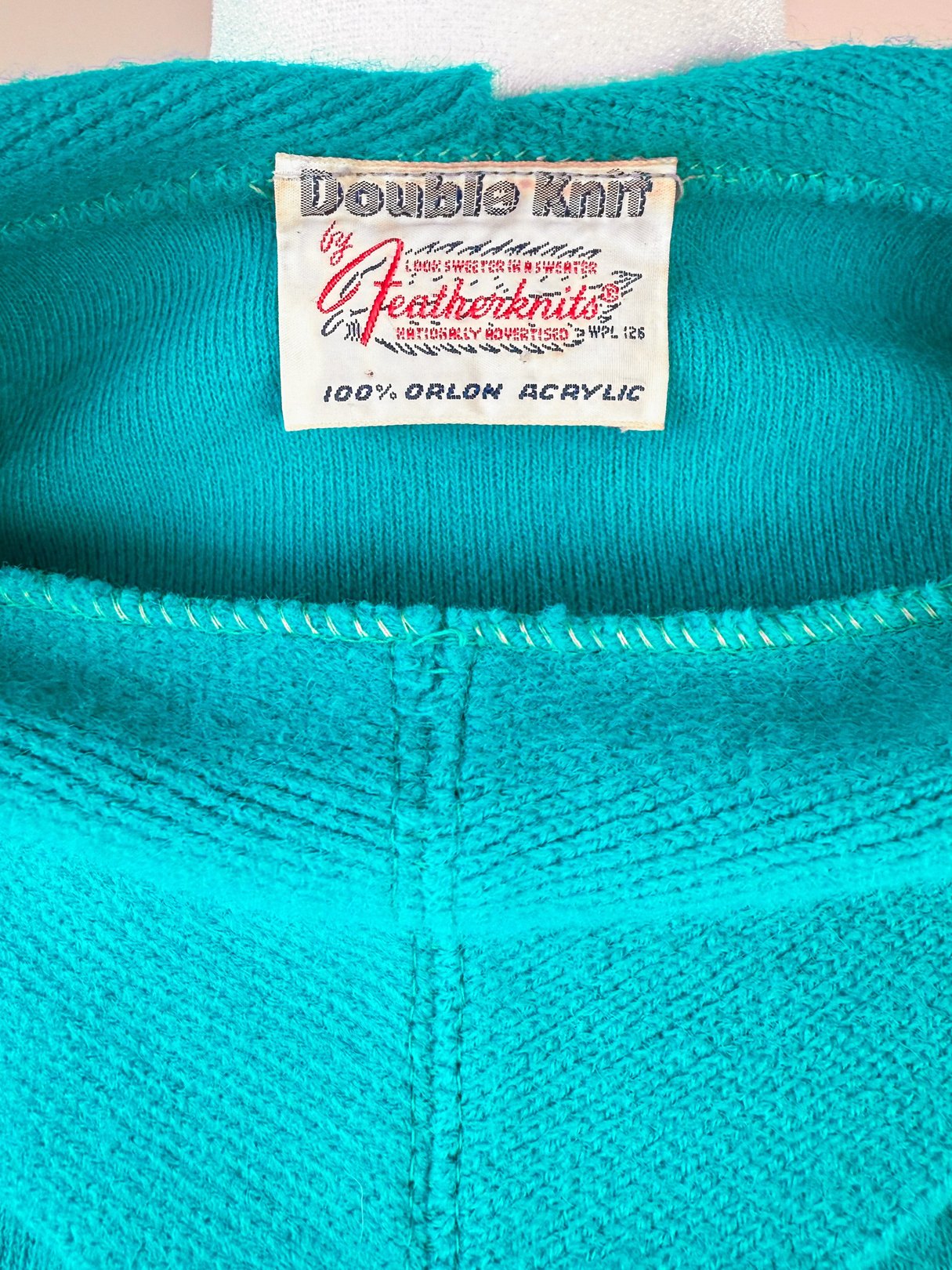 Teal green skirt set from the 1960s featuring a label that reads "Double Knit by Featherknits, 100% Orlon Acrylic.