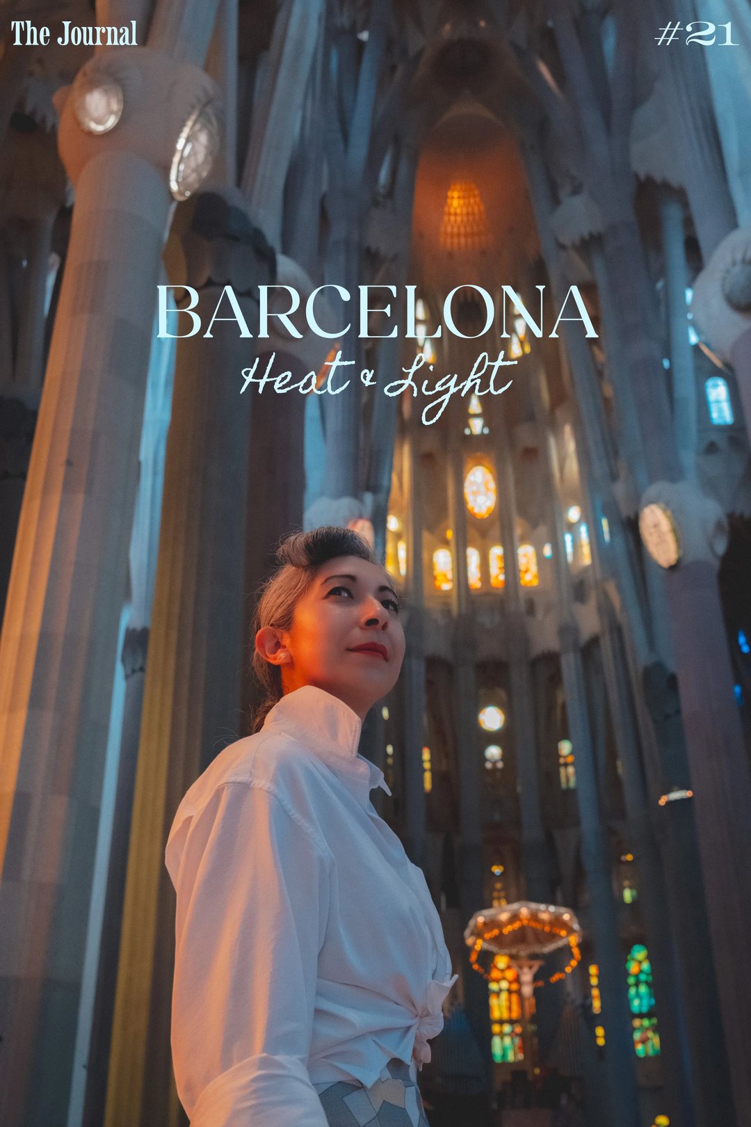 A woman gazes upward in the interior of a cathedral, illuminated by colorful stained glass.