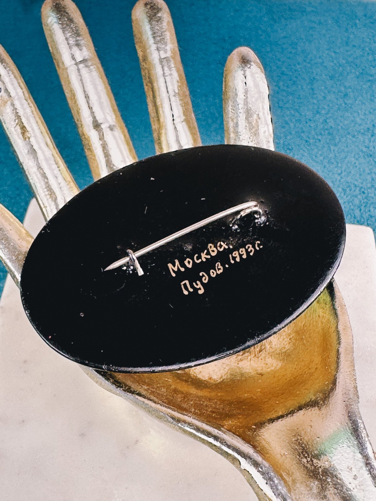 A black Fluttering Bird brooch from the 1970s, featuring a pin clasp and marked "Москва Пузов 1993.