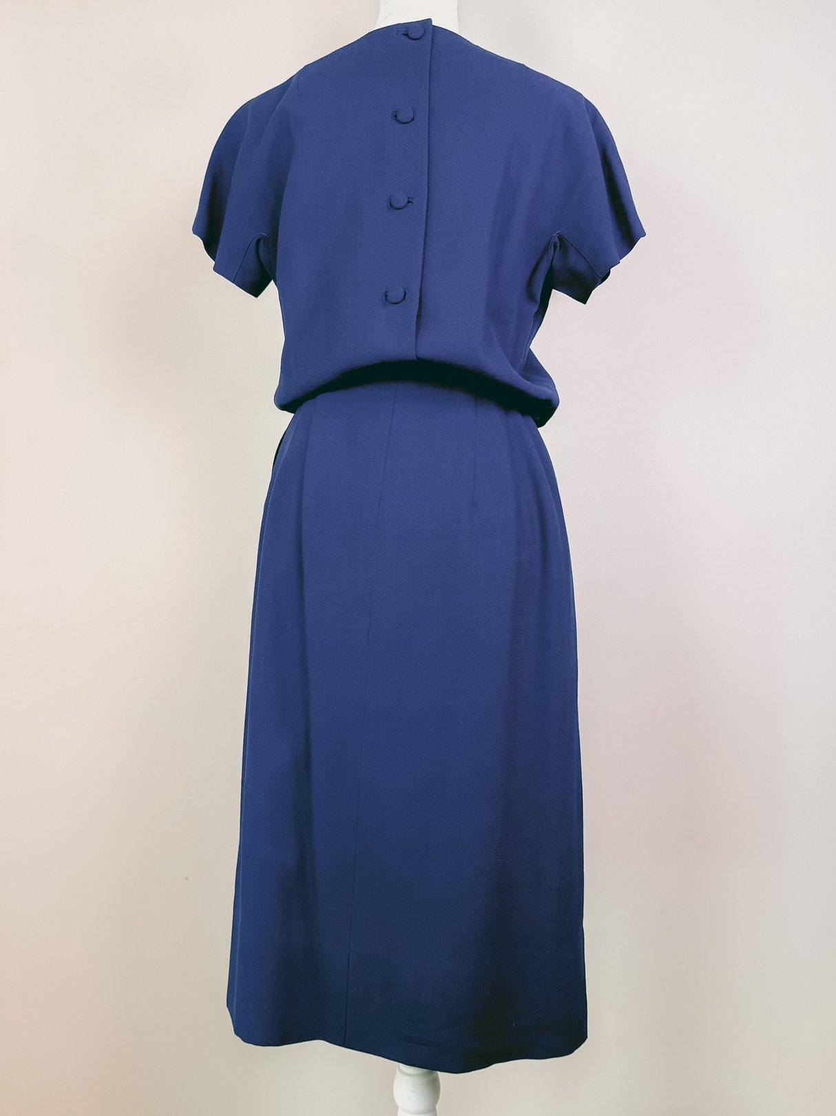 Navy blue women's 1960s dress set featuring a fitted silhouette and three back buttons.
