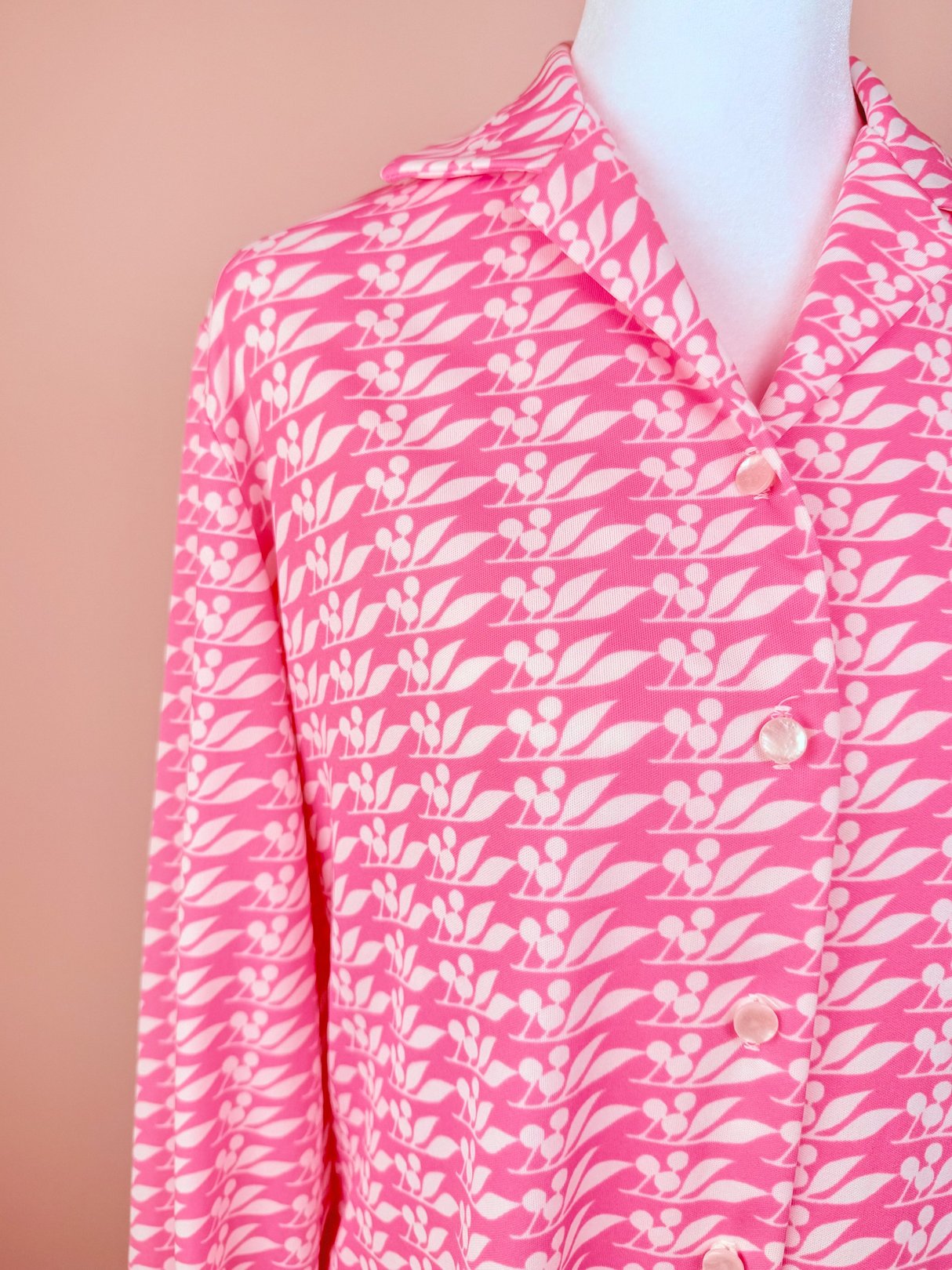 Pink 1970s blouse for women featuring a cherry petal print and button closure.