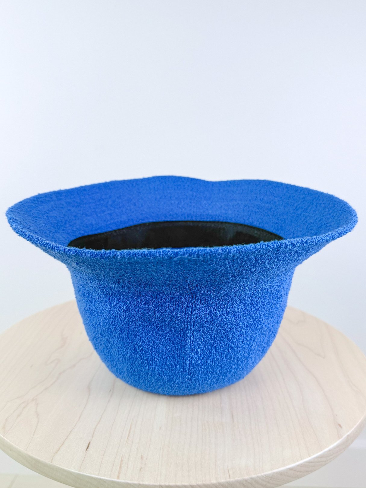 Electric blue bucket hat with a wide brim and textured fabric, designed for women and reflective of 1960s style.