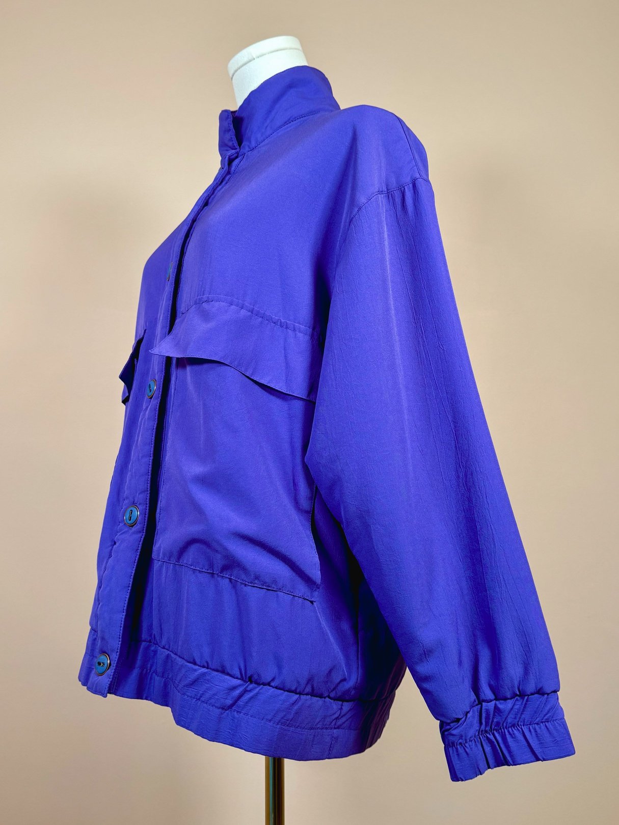 Vibrant violet women's jacket from the 1980s featuring a relaxed fit and two front pockets.