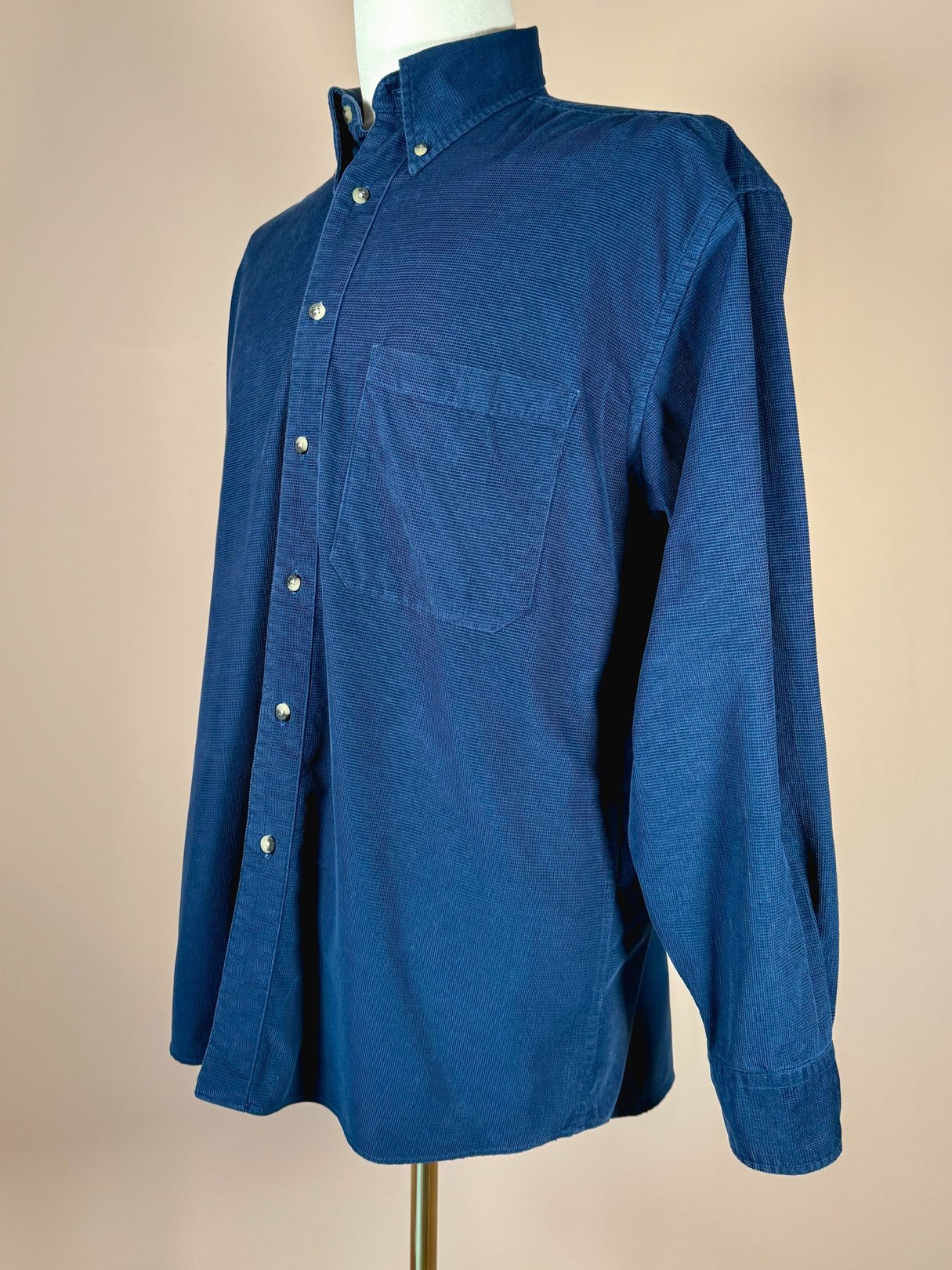 Navy blue men's cord shirt from the 1990s featuring a button-down collar and a single chest pocket.