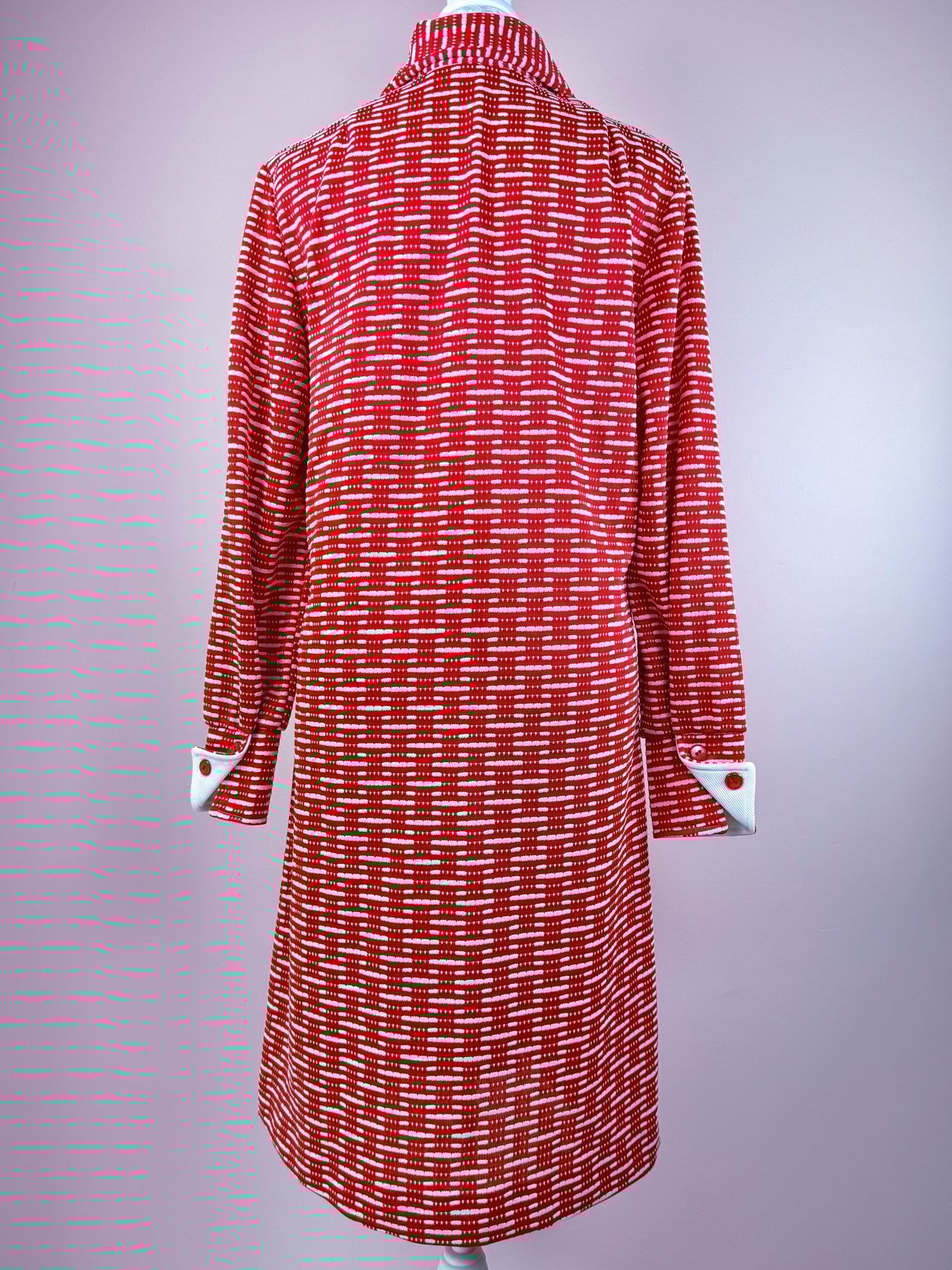 Red 1970s women's knit dress with a geometric pattern and long sleeves, featuring a collar and buttoned cuffs.