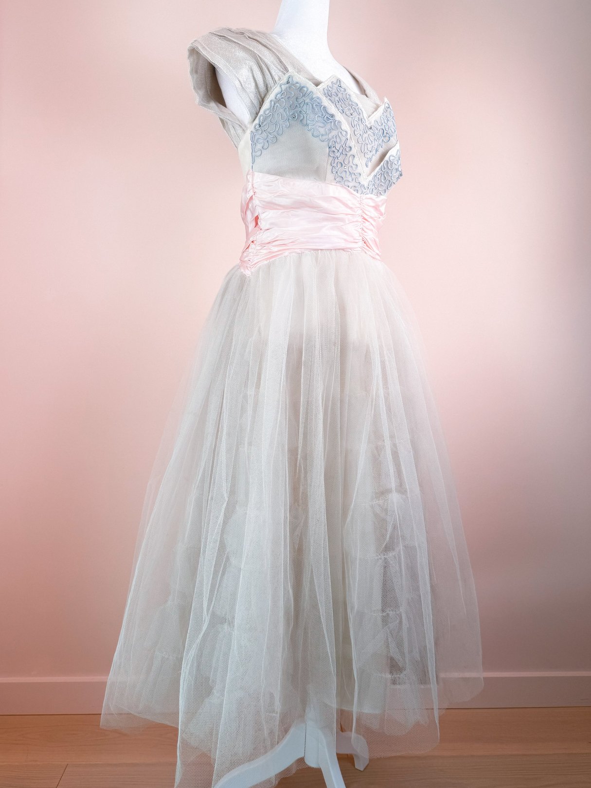 1950s women's Twilight Waltz Dress in silver with a fitted bodice, intricate detailing, and a layered tulle skirt.