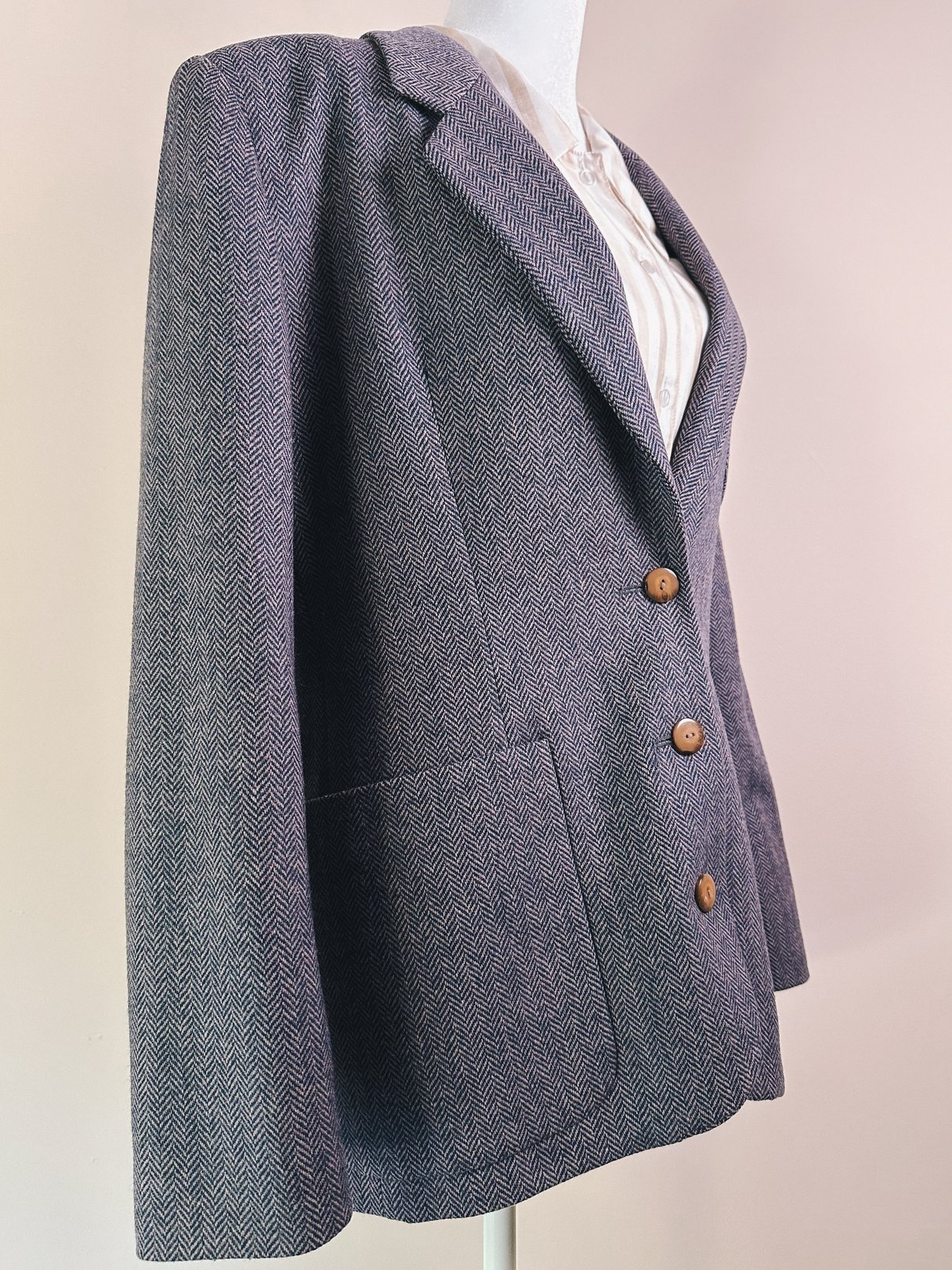 Mauve pink 1970s women's tweed blazer with three brown buttons and a textured herringbone pattern.