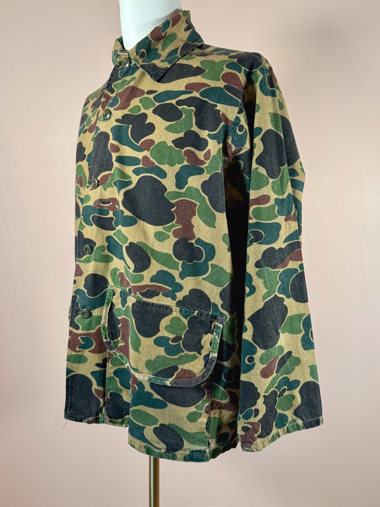 Camo jacket for men featuring a 1970s design in camouflage green with a buttoned collar and front pockets.