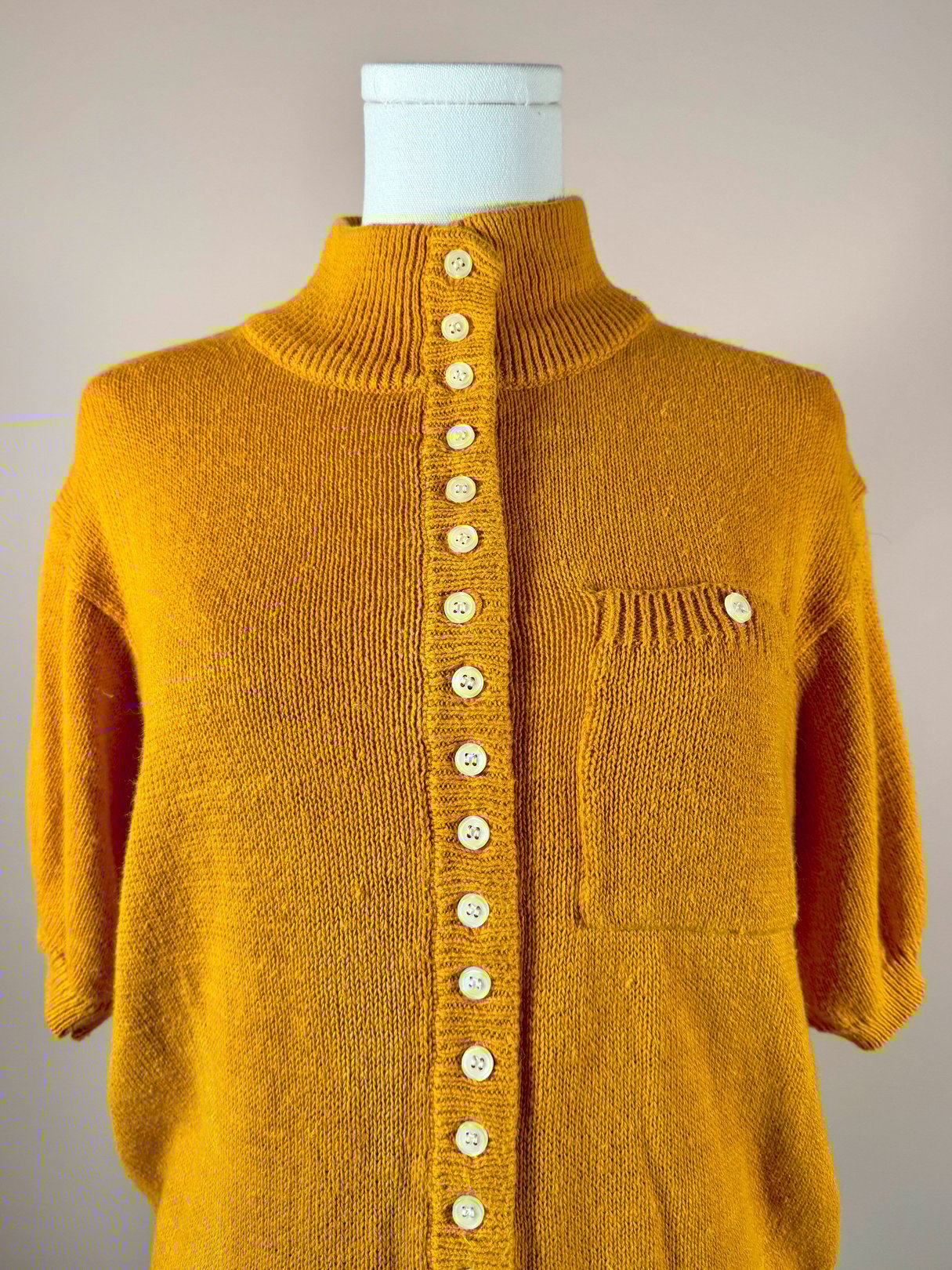 Persimmon orange women's sweater from the 1980s featuring a button-down front, a collar, and a chest pocket.