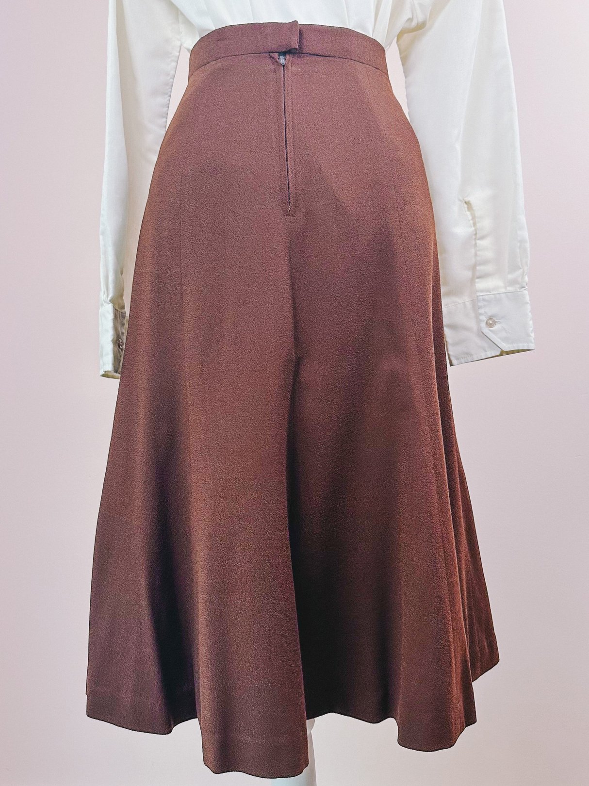 Brown women's skirt from the 1970s, featuring a flared silhouette and a back zipper.