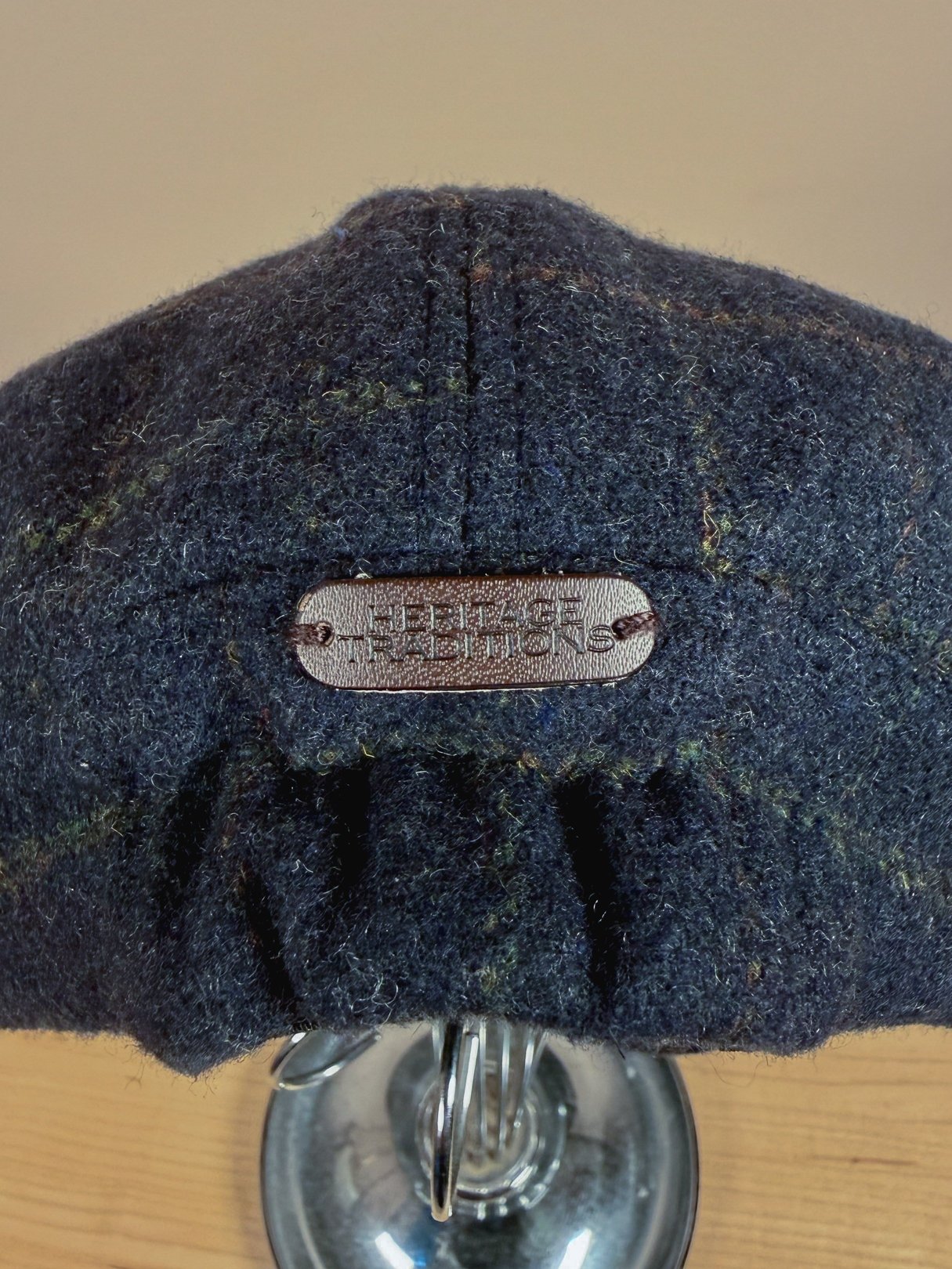 Navy blue men's cap from the 1970s featuring a textured tweed fabric and a label on the back.