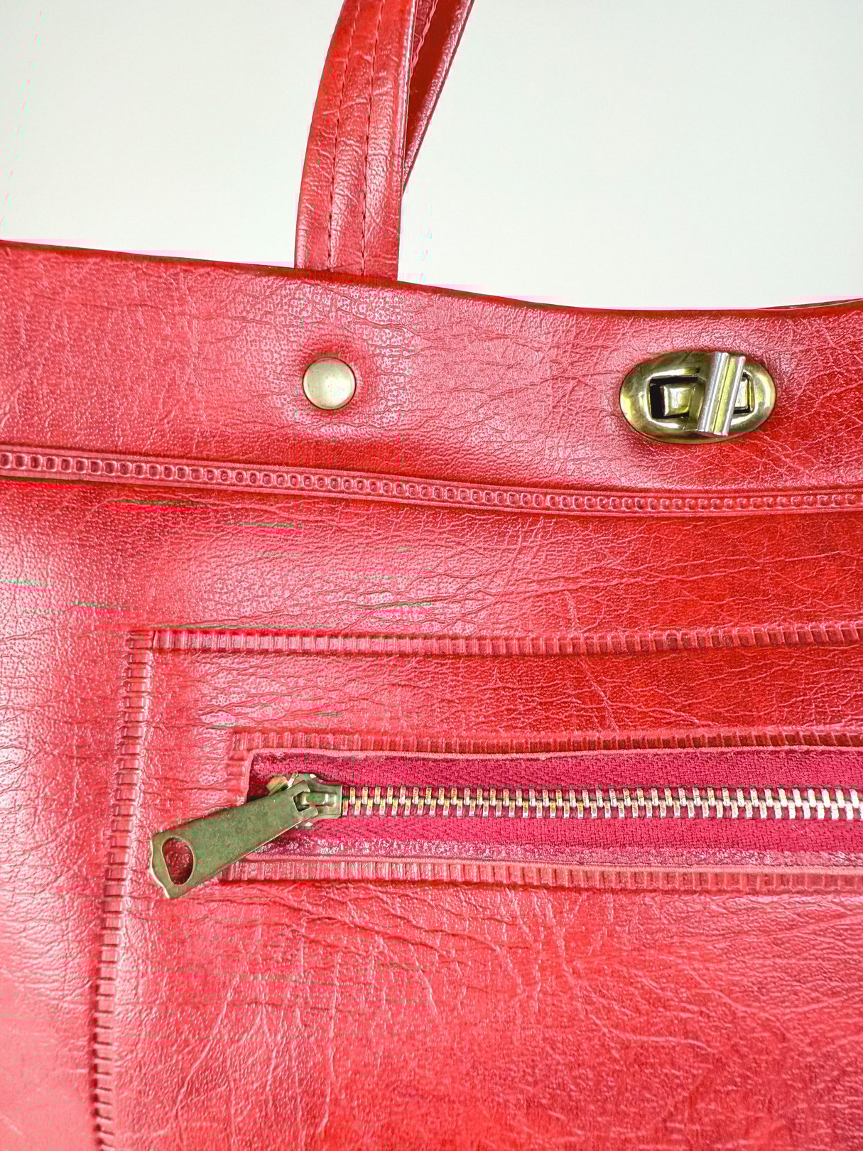 Redline Retro Satchel Tote in red faux leather featuring a zippered pocket and brass hardware, designed for women in a 1970s style.