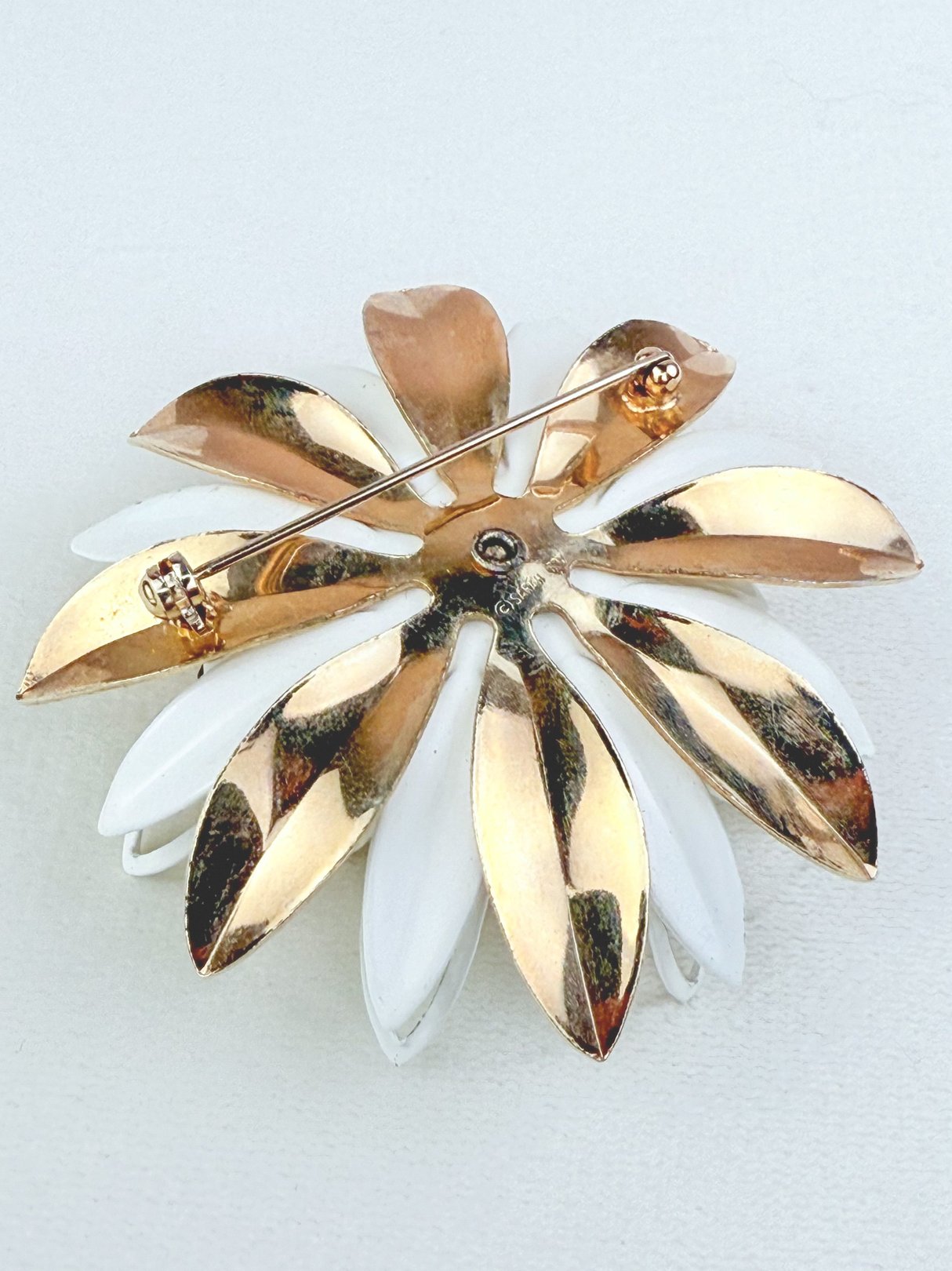Gilded Dahlia brooch featuring gold and white petals with a pin clasp, typical of 1950s jewelry design.