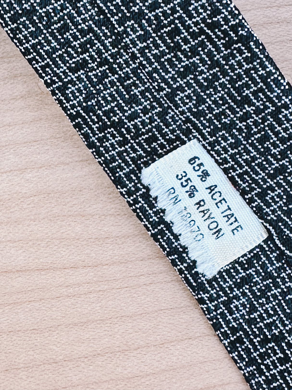 Black 1950s skinny tie made of 65% acetate and 35% rayon, featuring a textured pattern.