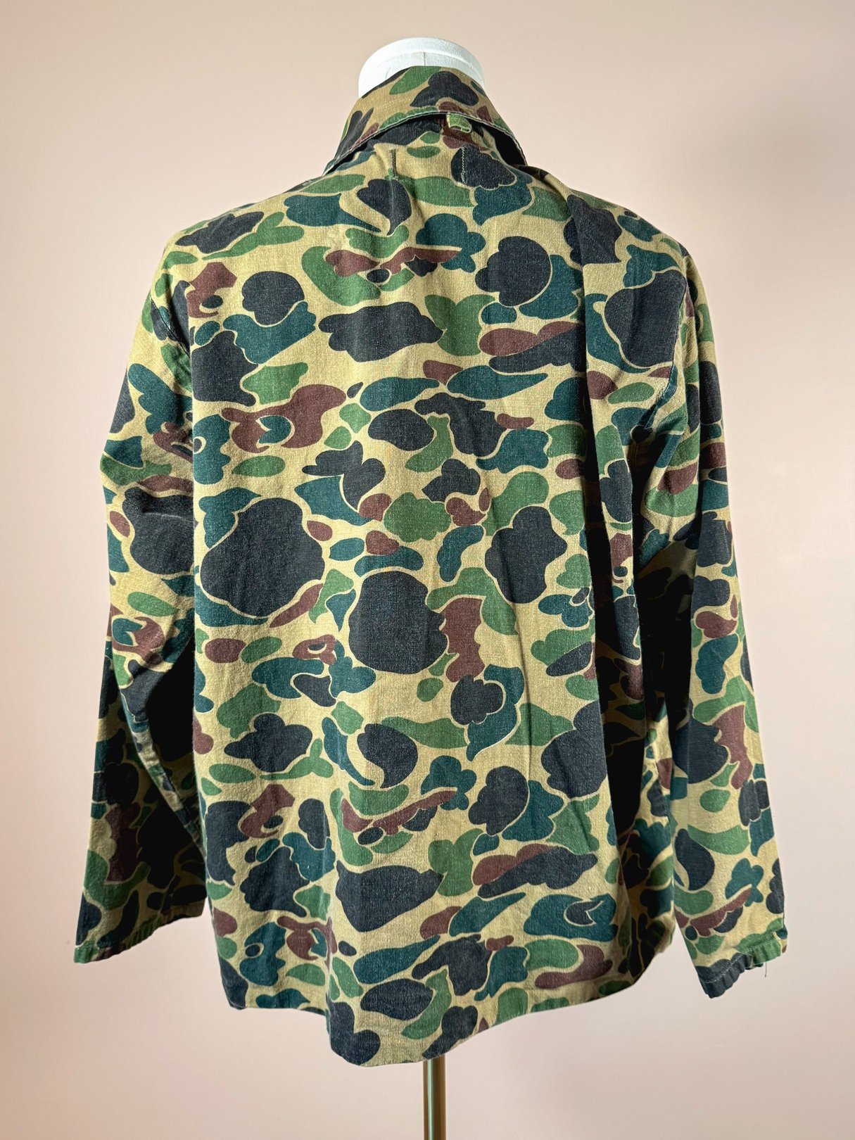 A men's 1970s camo jacket in shades of camouflage green with a relaxed fit.