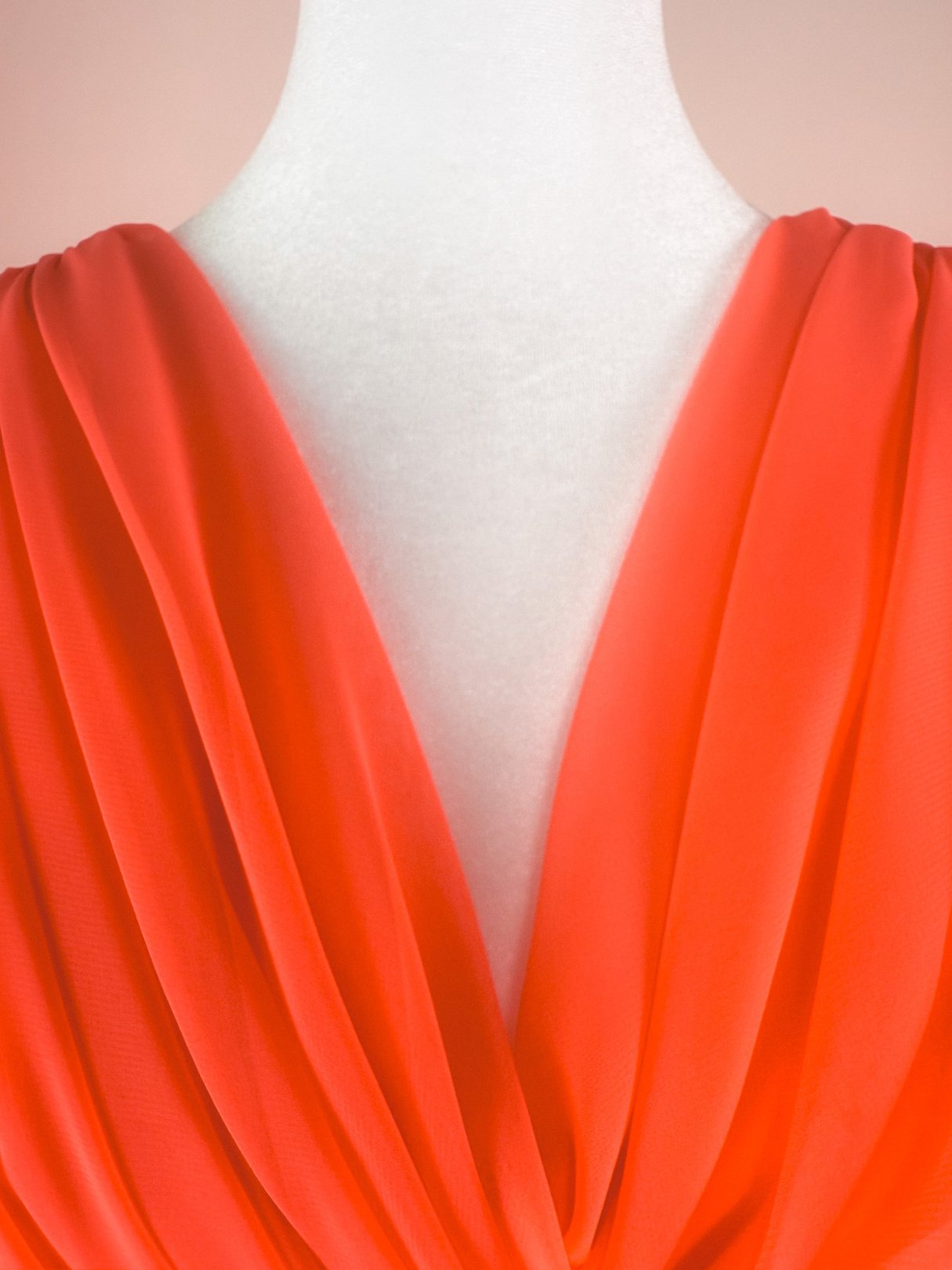 Coral Soirée Dress features a deep V-back design and flowing fabric, characteristic of women's 1960s fashion.