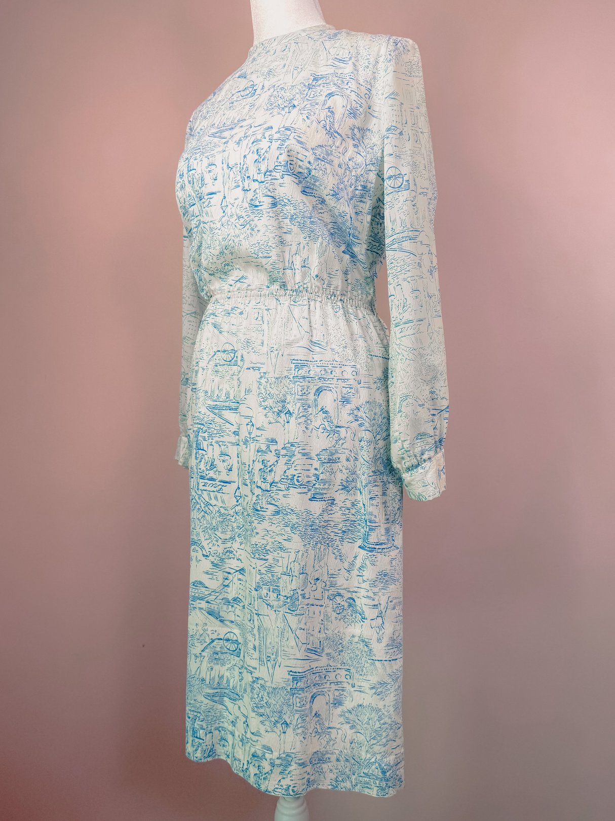 Blue 1960s women's dress featuring a montage print with a waistline cinched by elastic.