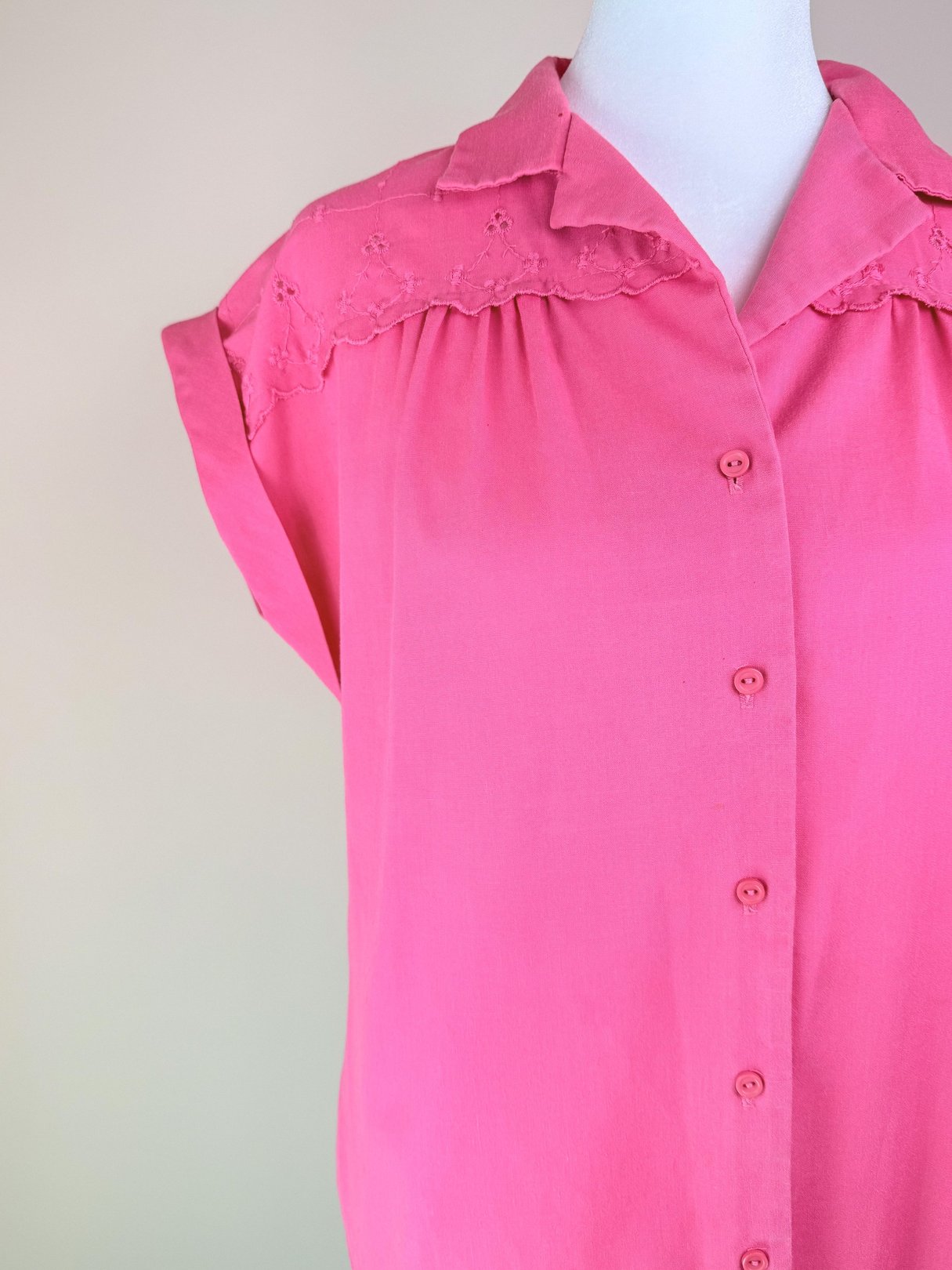 Pink sleeveless top featuring lace detailing and button closure, styled for women in the 1980s.