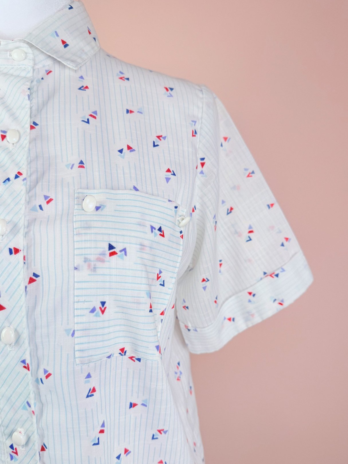 Blue 1980s women's top featuring a geometric pattern and a front pocket.