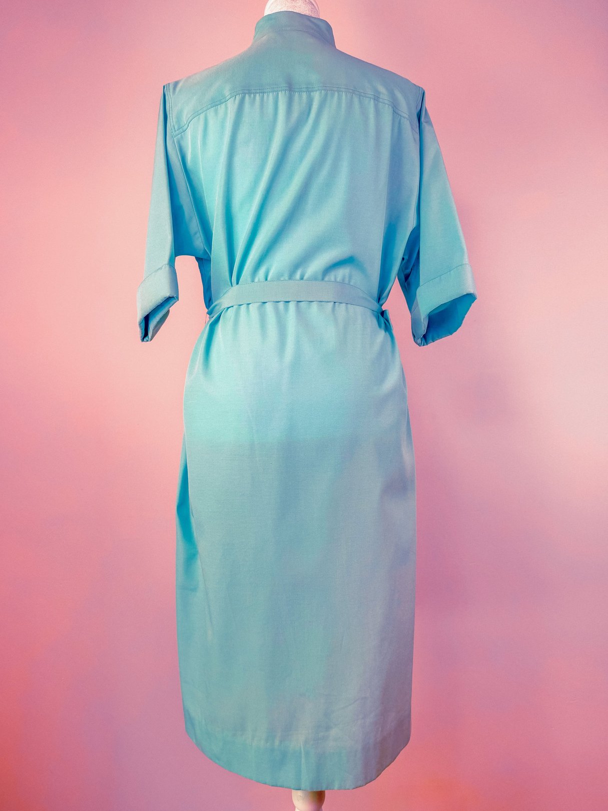 Sky blue 1960s women’s Skyline Shift Dress with a belted waist and rolled sleeves.