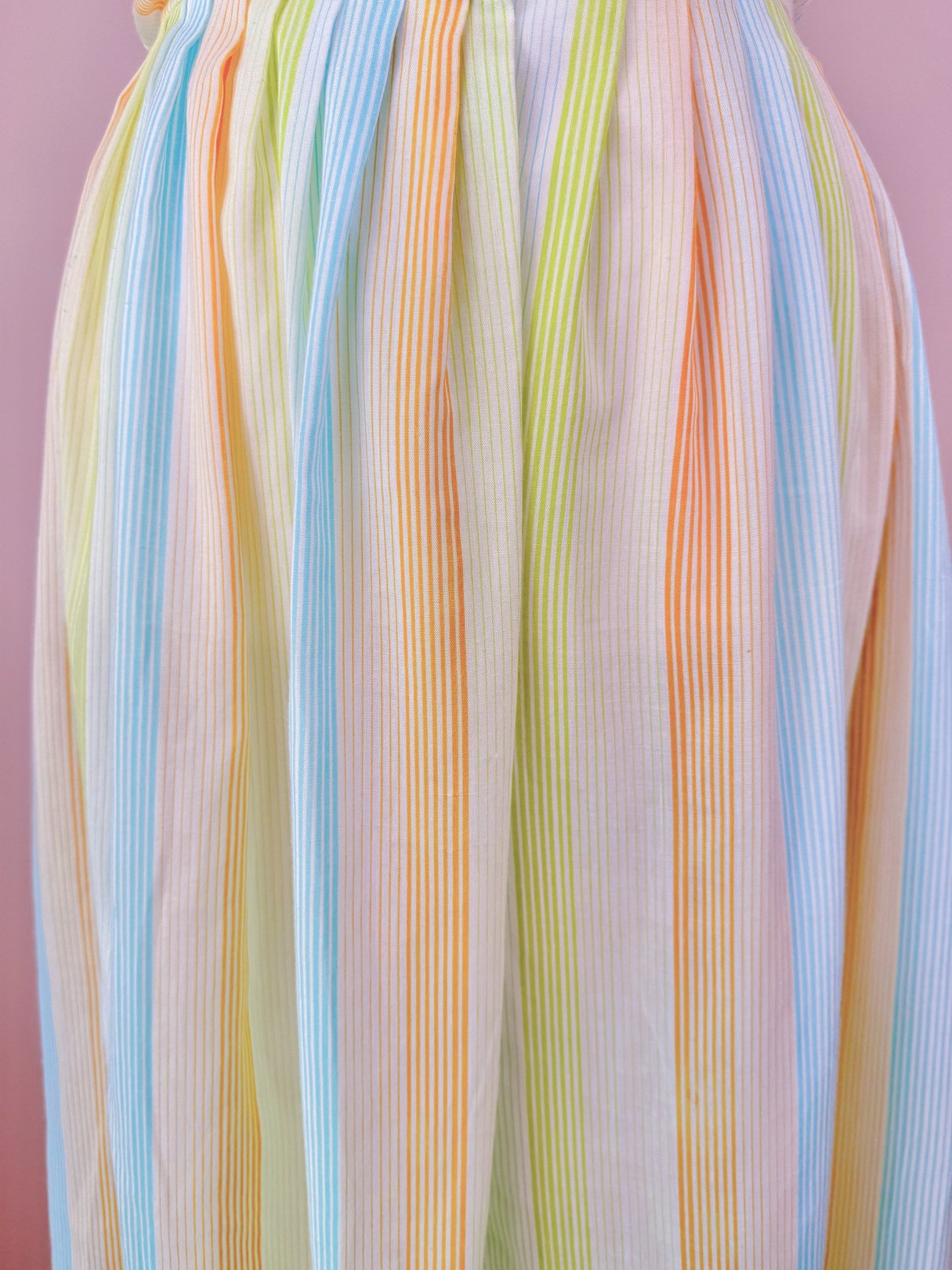1950s women's Citrus Dress featuring a pleated design with orange, yellow, and blue stripes.