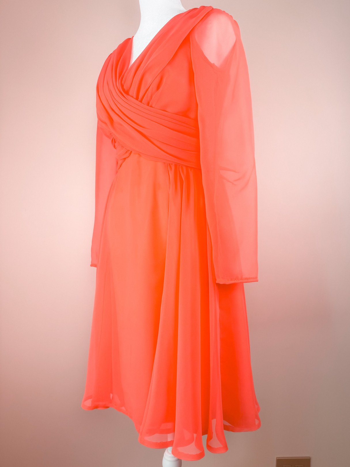 Coral Soirée Dress featuring long sleeves, a draped bodice, and a flowing skirt, typical of 1960s women's fashion.