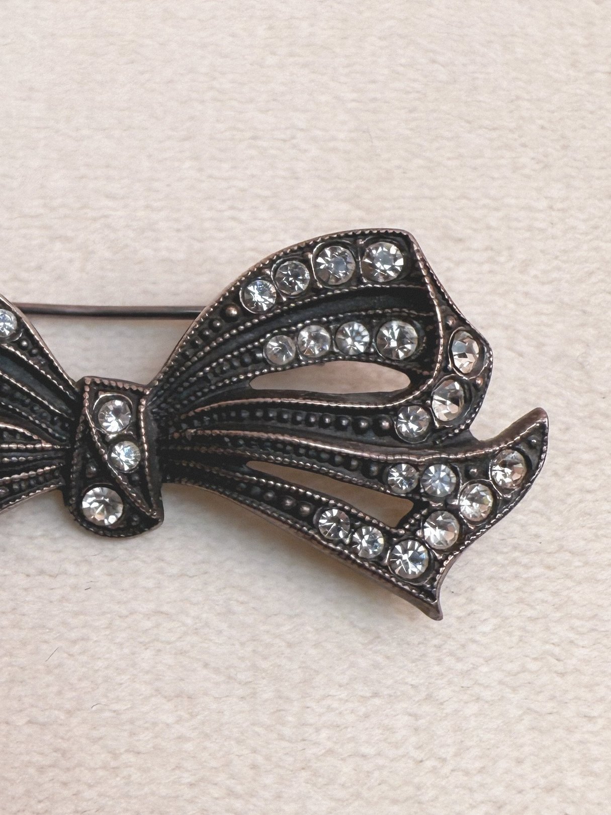 A silver 1970s Deco Bow Pin embellished with glass rhinestones.