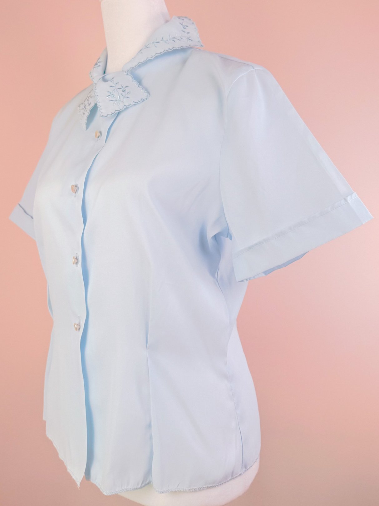 Powder blue blouse for women from the 1950s featuring a decorative collar and short sleeves.