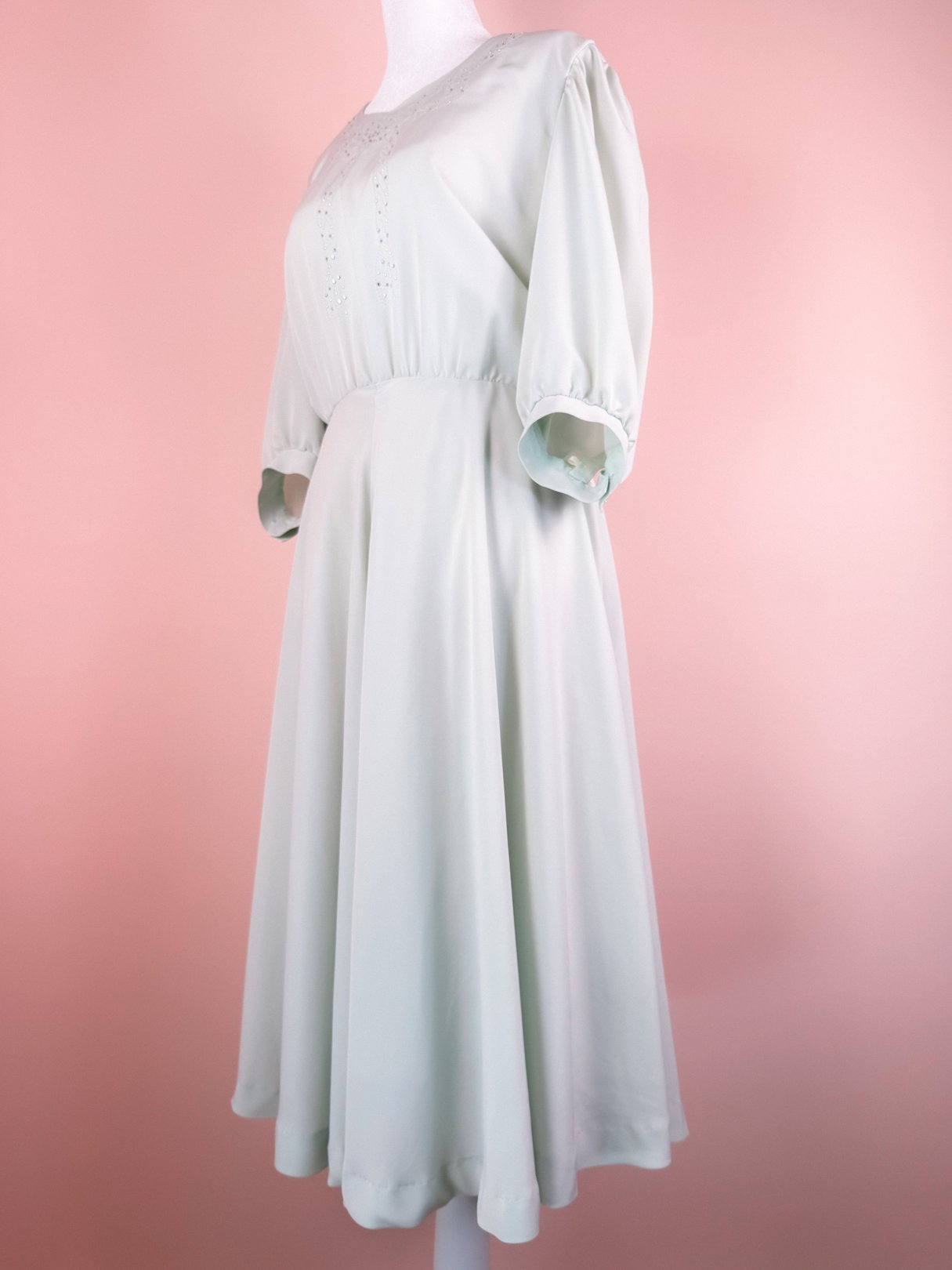 Mint green 1980s women's dress with a sparkling neckline and mid-length sleeves, featuring a flowing skirt.